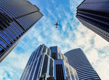 plane flying above buildings