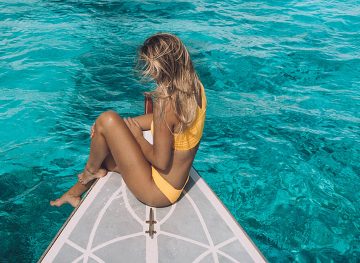 Écrans solaires respectueux des récifs pour les destinations tropicales Girl Yellow Bikini Ocean Water