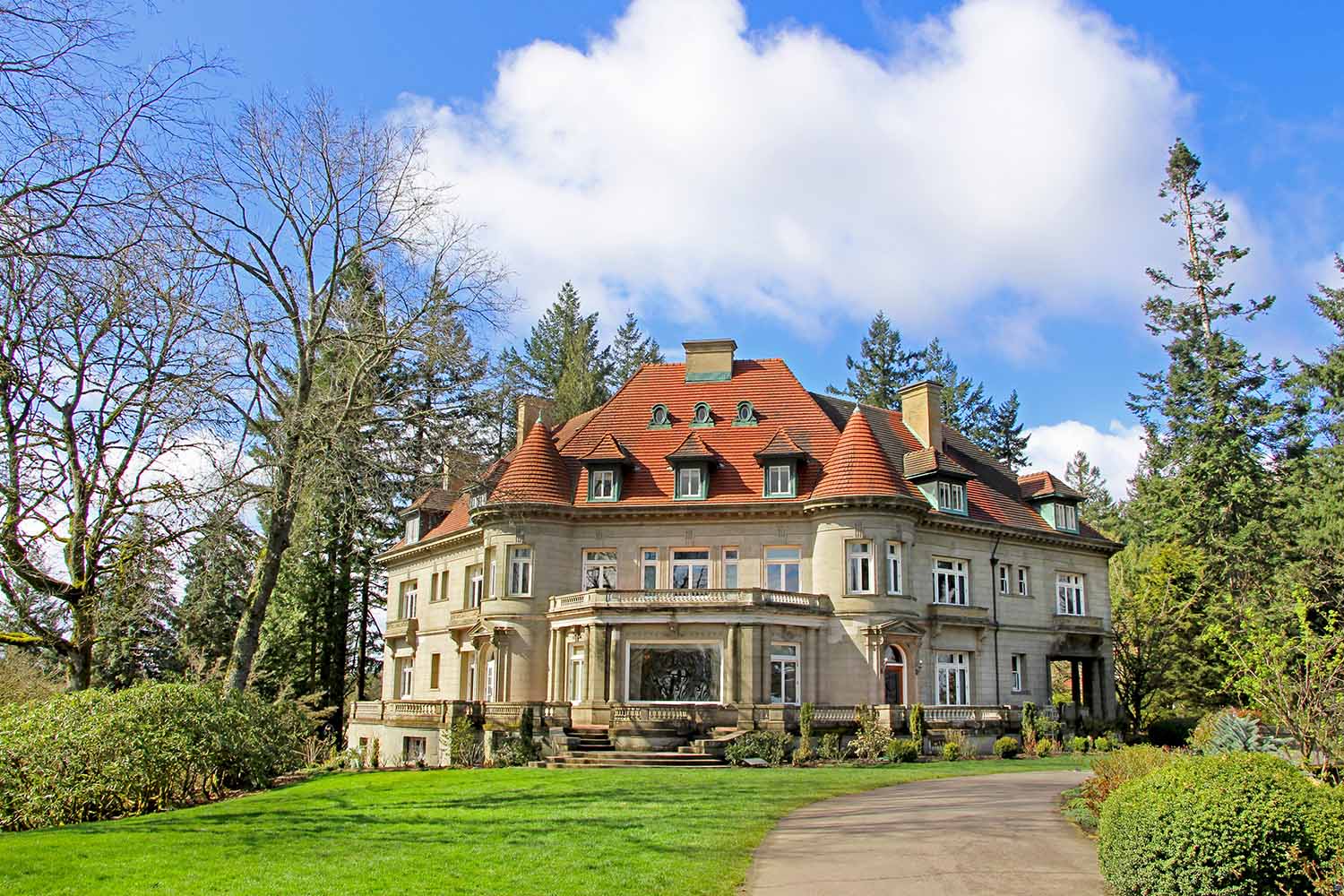 Pittock Mansion, view on the house surrounded by trees from the garden on a beautiful sunny spring day, Portland USA